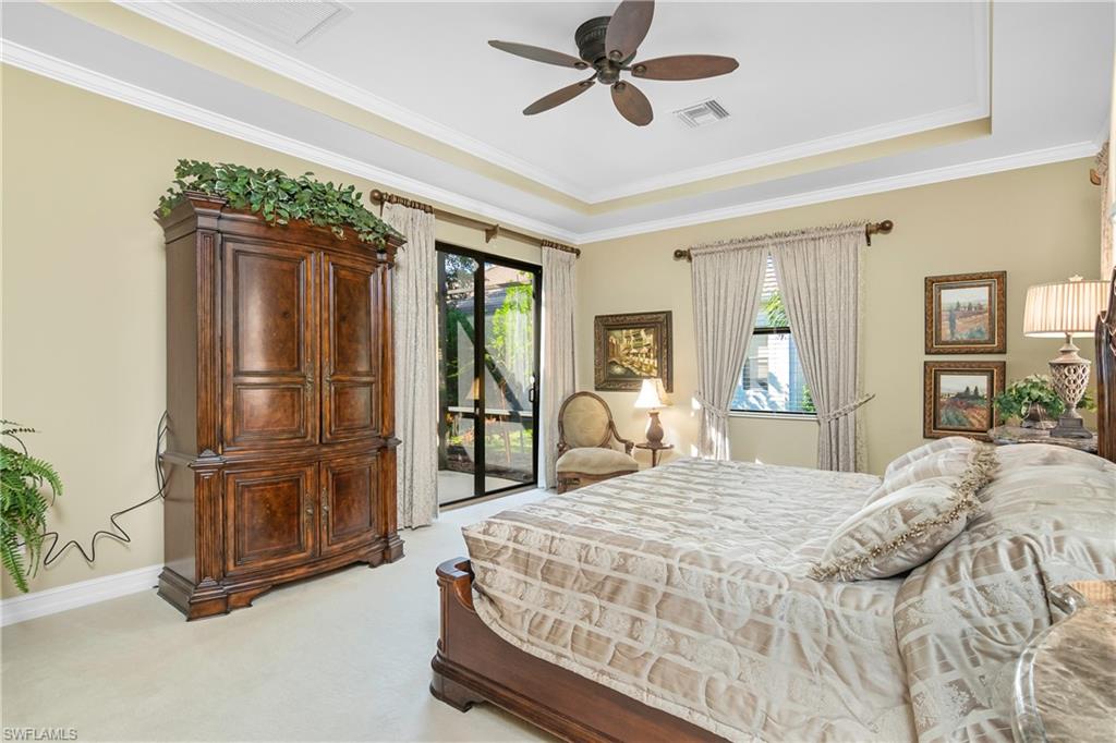 1349 Serrano Circle Naples, FL 34105 - Photo 3 of 37 a spacious bedroom with a bed a dresser and a chandelier