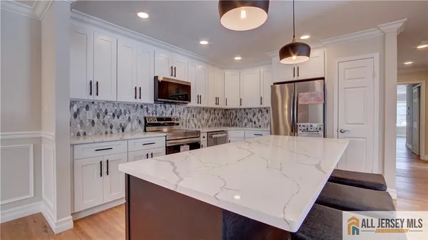 a kitchen with kitchen island granite countertop a sink cabinets and stainless steel appliances