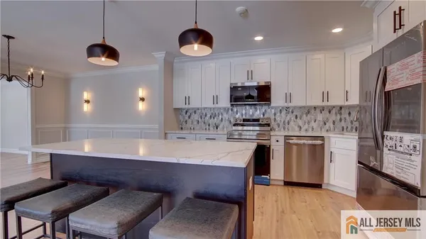 a kitchen with stainless steel appliances kitchen island granite countertop a stove a sink and a microwave