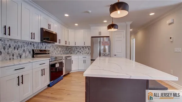 a kitchen with a stove cabinets and wooden floor