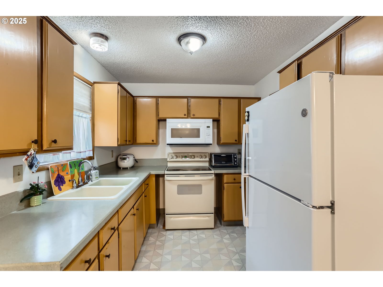 12330 Southeast Main Street Portland, OR 97233 - Photo 11 of 28 a kitchen with a sink a refrigerator and a stove