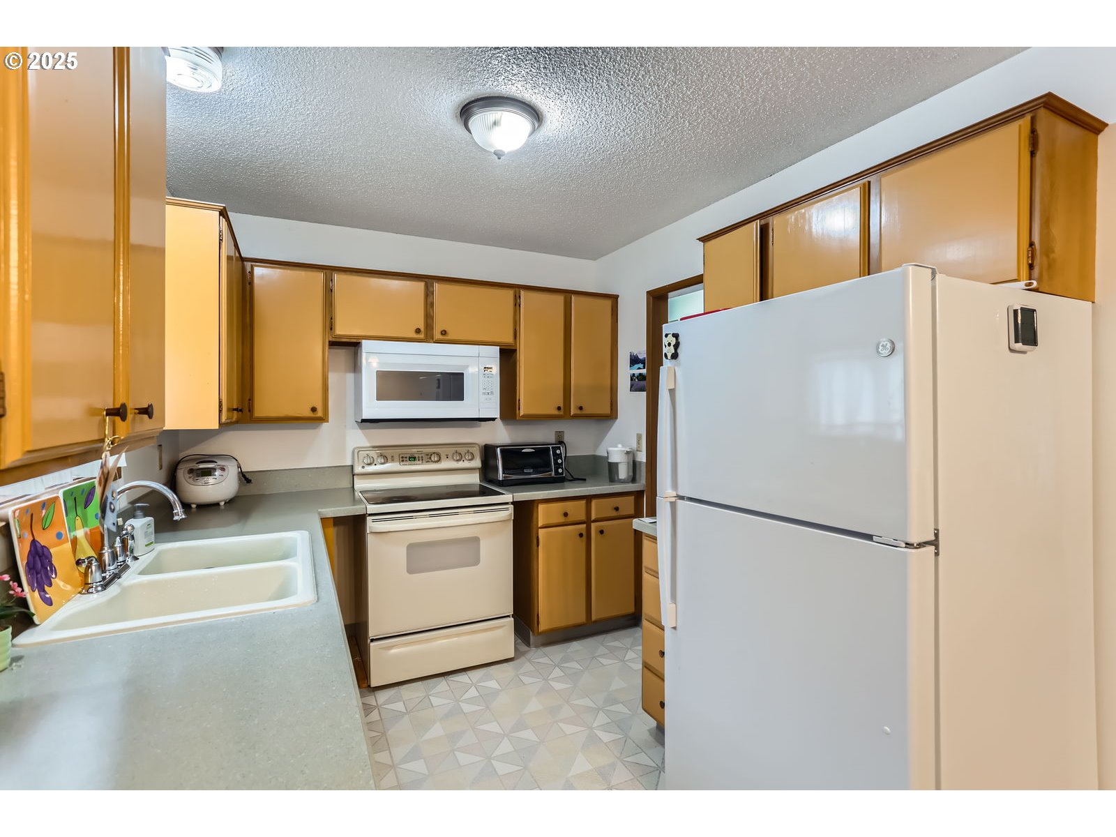 12330 Southeast Main Street Portland, OR 97233 - Photo 12 of 28 a kitchen with a refrigerator a stove top oven a sink and a window