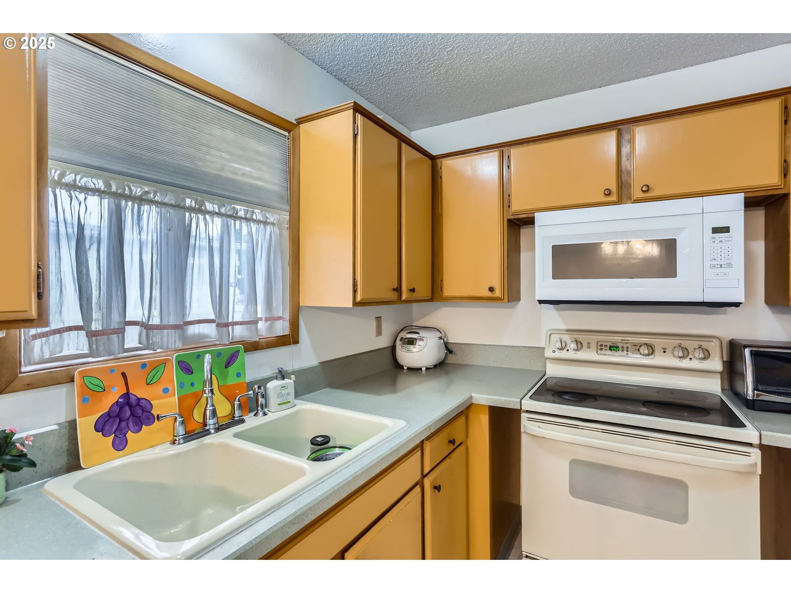 12330 Southeast Main Street Portland, OR 97233 - Photo 13 of 28 a kitchen with a stove a sink and a microwave