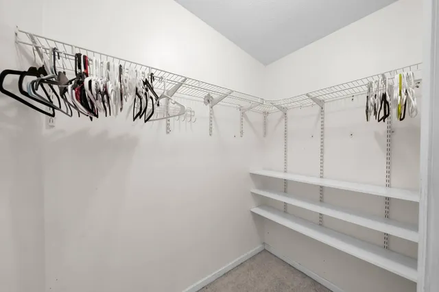 a view of walk in closet with empty racks