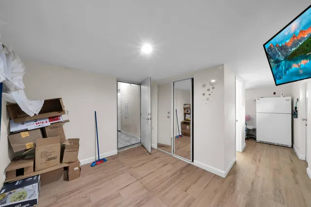 a view of a livingroom with wooden floor and a flat screen tv