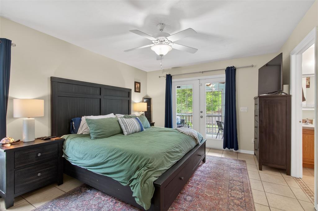4729 Northeast 16th Terrace Gainesville, FL 32609 - Photo 13 of 41 a bedroom with a large bed and a chandelier