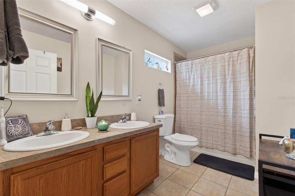 4729 Northeast 16th Terrace Gainesville, FL 32609 - Photo 15 of 41 a bathroom with a double vanity sink toilet and a mirror