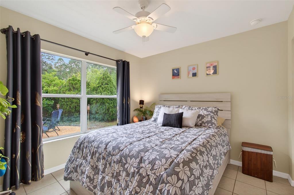 4729 Northeast 16th Terrace Gainesville, FL 32609 - Photo 24 of 41 a bedroom with a large bed and a chandelier