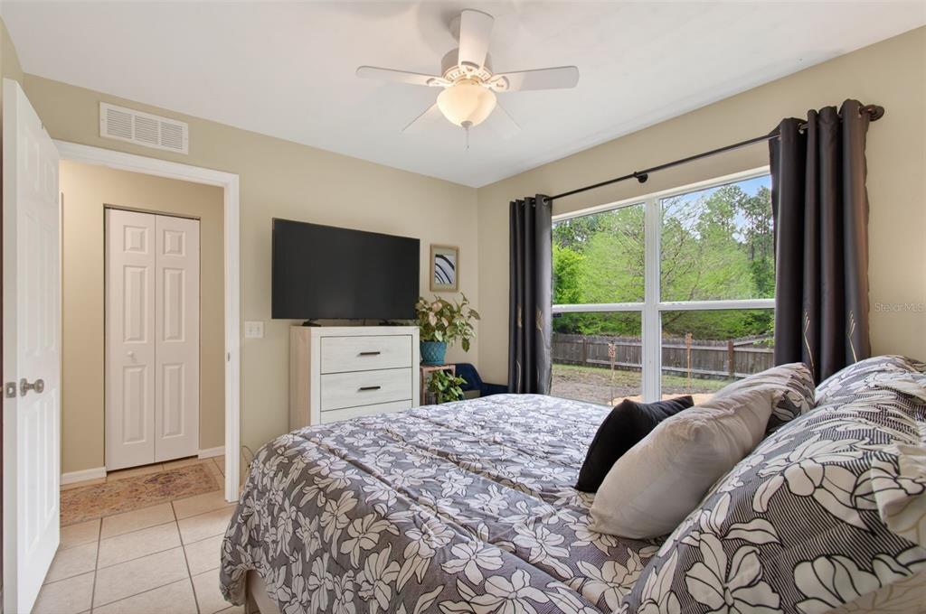 4729 Northeast 16th Terrace Gainesville, FL 32609 - Photo 25 of 41 a bedroom with a large bed and a flat tv screen on dresser