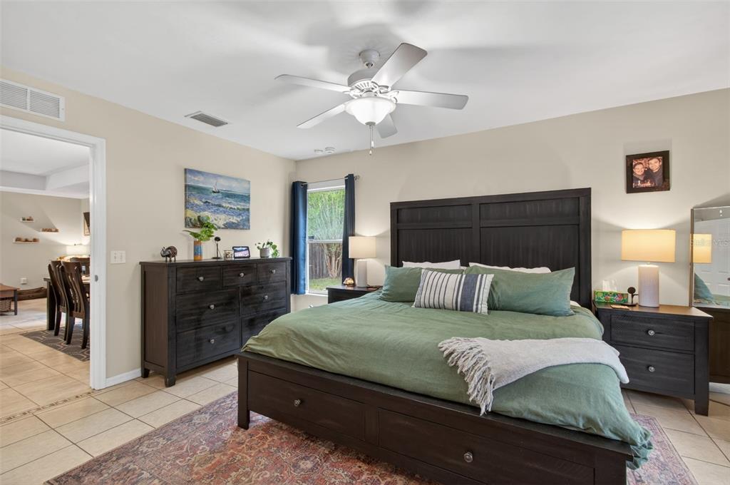 4729 Northeast 16th Terrace Gainesville, FL 32609 - Photo 3 of 41 a bedroom with a large bed and a chandelier