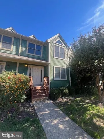 a front view of a house with garden and trees