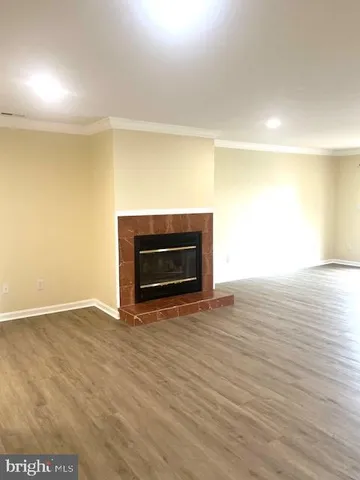 a view of empty room with wooden floor and fireplace
