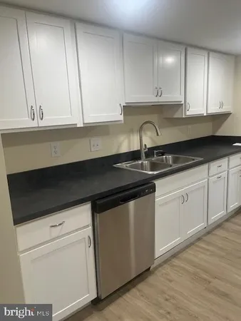 a kitchen with granite countertop white cabinets and sink