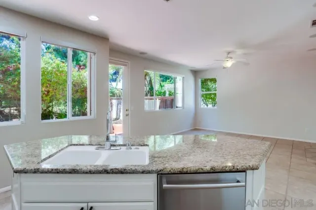 a kitchen with granite countertop kitchen island a counter space and windows