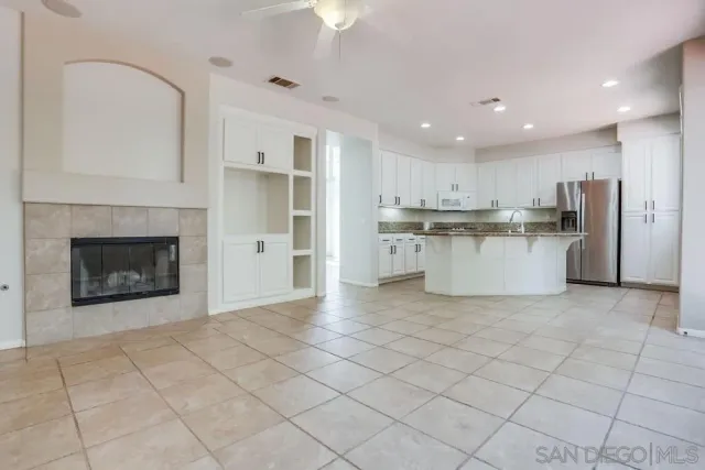 a view of a kitchen with a sink a fireplace and a window