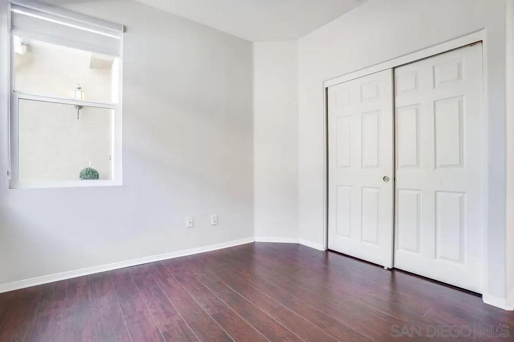 5423 Foxtail Loop Carlsbad, CA 92010 - Photo 24 of 53 an empty room with wooden floor and closet area