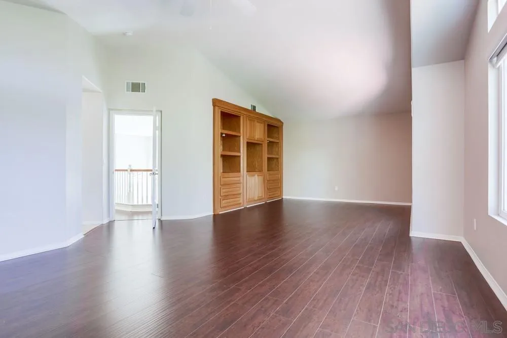 5423 Foxtail Loop Carlsbad, CA 92010 - Photo 32 of 53 an empty room with wooden floor and windows