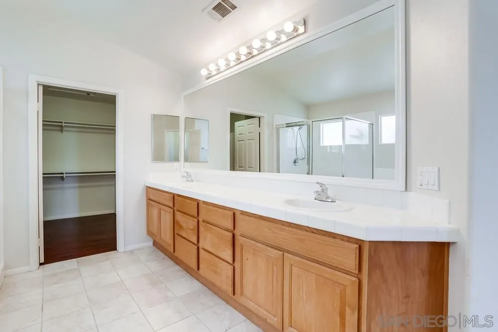5423 Foxtail Loop Carlsbad, CA 92010 - Photo 34 of 53 a spacious bathroom with a double vanity sink and a mirror