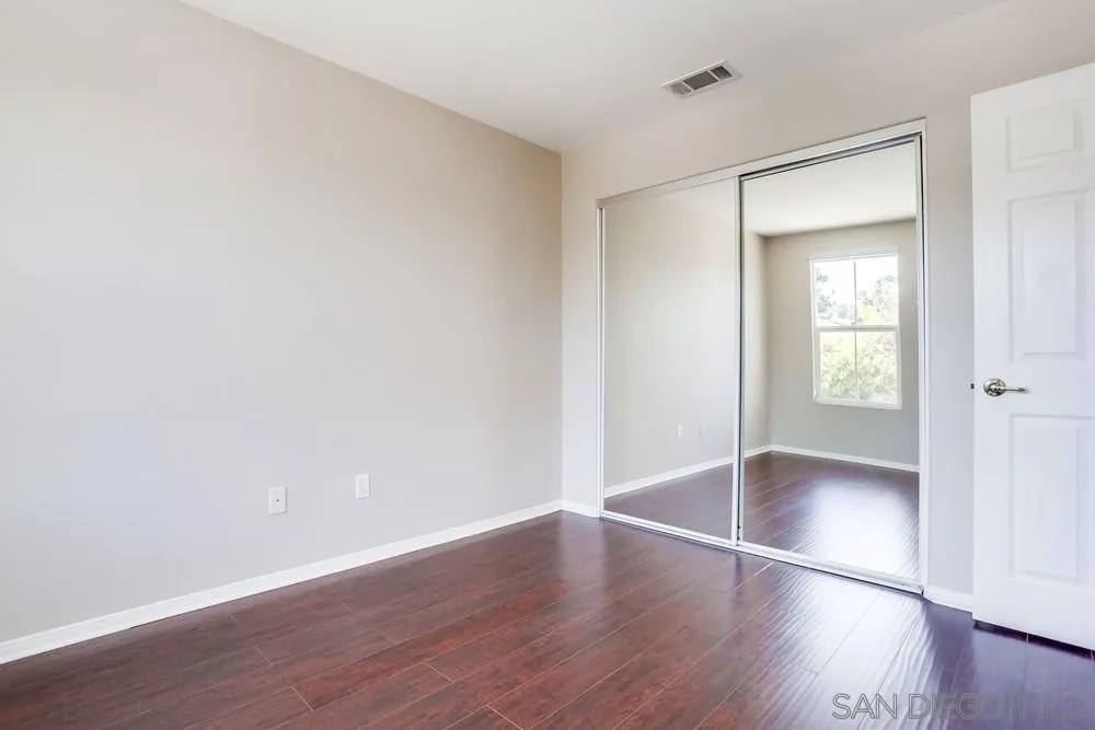 5423 Foxtail Loop Carlsbad, CA 92010 - Photo 39 of 53 an empty room with wooden floor and windows