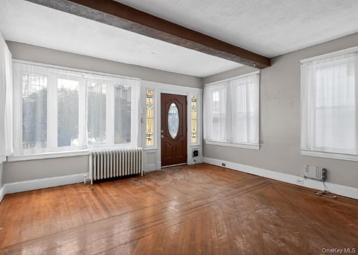 64 Watchogue Road Staten Island, NY 10314 - Photo 5 of 23 an empty room with wooden floor and windows