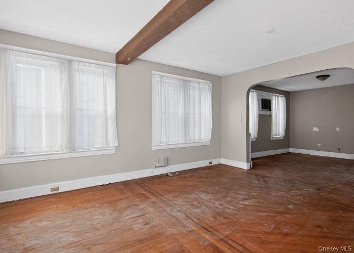 64 Watchogue Road Staten Island, NY 10314 - Photo 9 of 23 a view of an empty room with wooden floor and a window