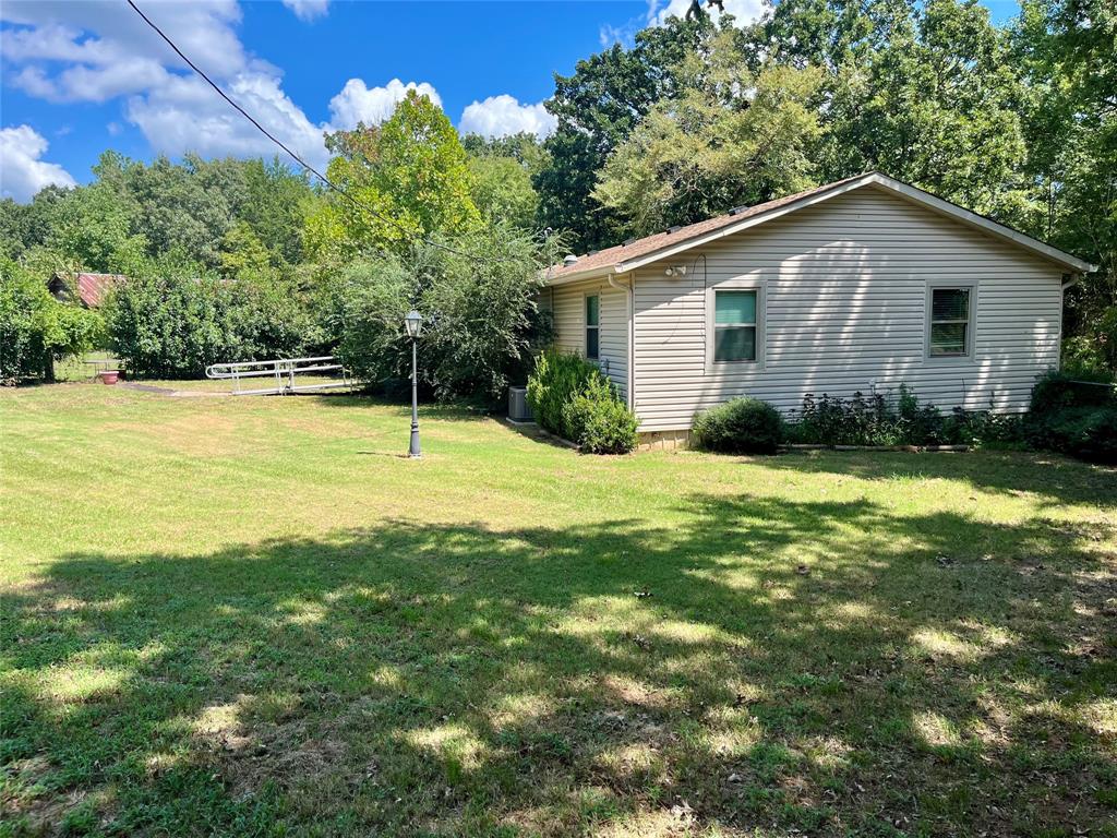 4546 Farm To Market 515 Quitman, TX 75783 - Photo 2 of 17 a view of a backyard with plants and large tree