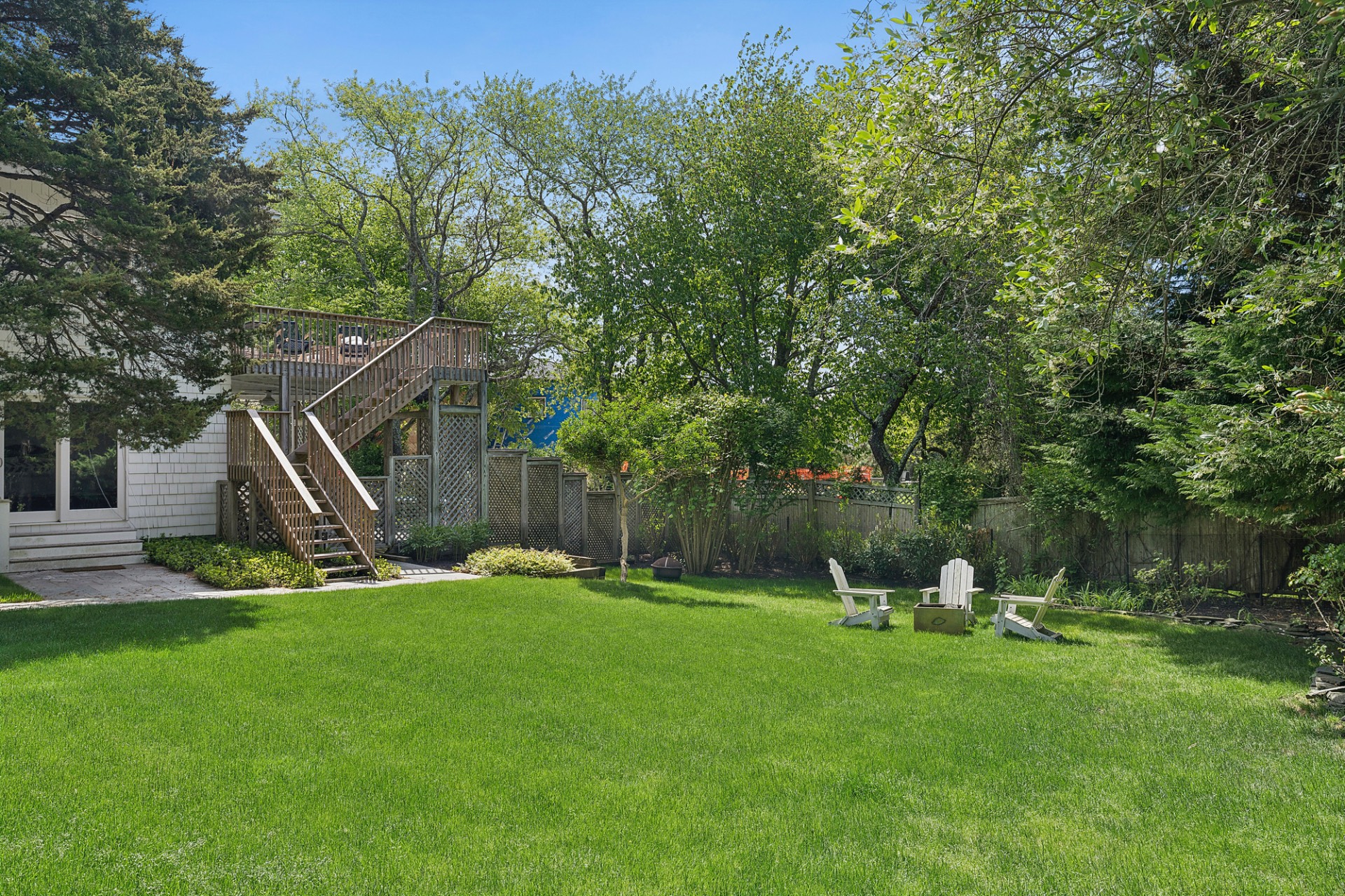 29 Petrel Road Southampton, NY 11968 - Photo 35 of 37 a view of a backyard with a slide trees and wooden fence