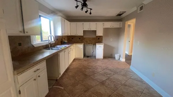 a kitchen with a sink window and cabinets