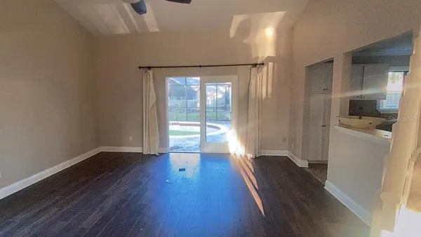wooden floor in an empty room with a kitchen