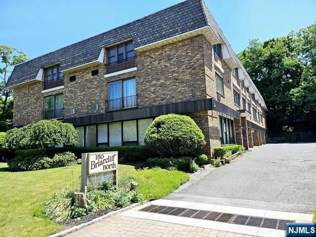150 County Road, Unit 18 Tenafly, NJ 07670 - Photo 1 of 15 a brick building with a bench in front of it