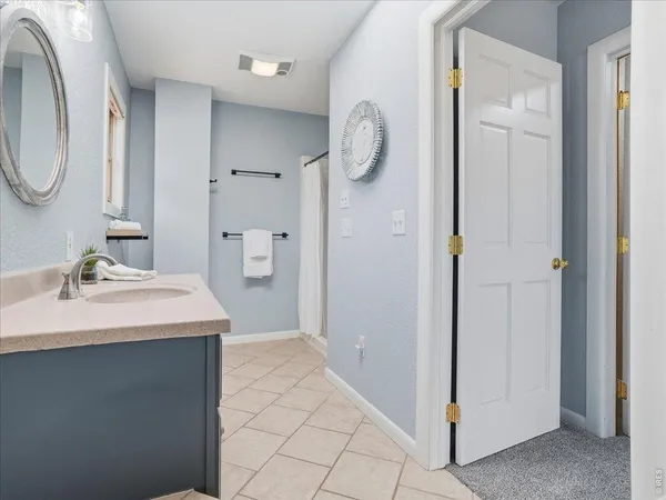 a spacious bedroom with a bed and glass walk in closet