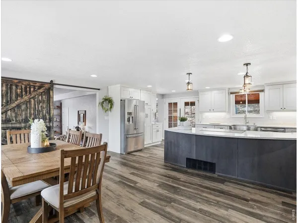 a large kitchen with stainless steel appliances a large counter top a stove a chimney a sink and a large window