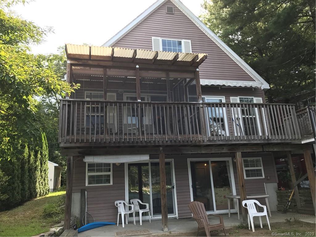 a view of a house with wooden deck and furniture