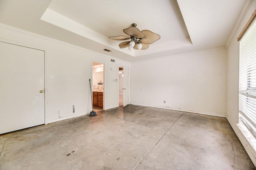 298 Butterfield Road Denison, TX 75021 - Photo 7 of 34 Spacious room featuring a tray ceiling with a ceiling fan, concrete flooring, and crown molding
