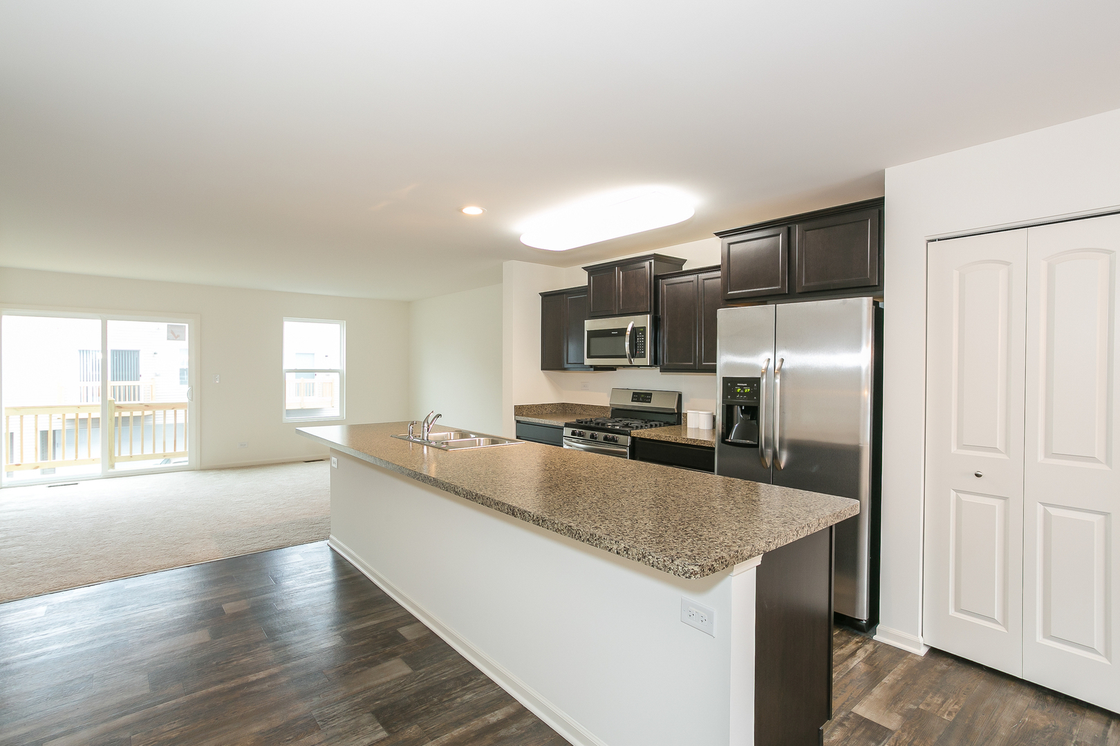 2364 Upland Road, Unit 2265 Pingree Grove, IL 60140 - Photo 3 of 18 a large kitchen with a center island and stainless steel appliances
