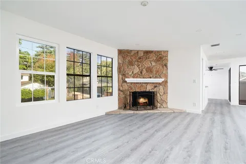 wooden floor fireplace and windows in an empty room