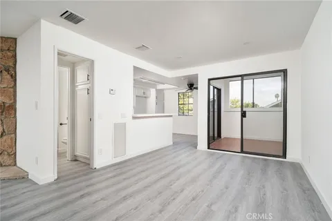 an empty room with wooden floor & windows