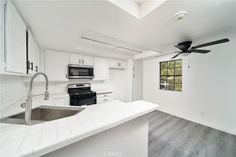 a kitchen with granite countertop a sink stainless steel appliances and cabinets