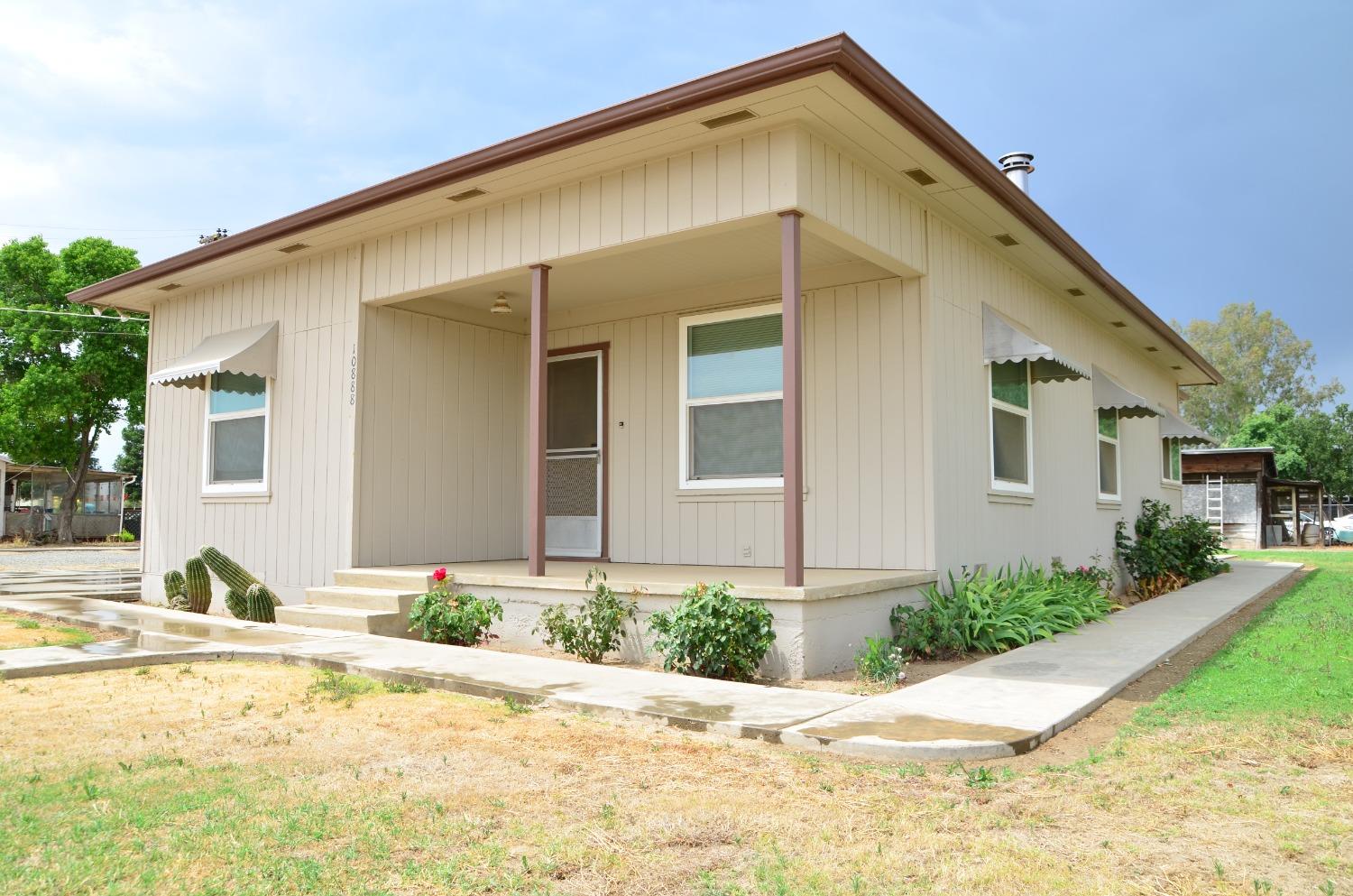 10888 Ave 412 Dinuba, CA 93618 - Photo 3 of 15 a front view of a house with a yard and garage