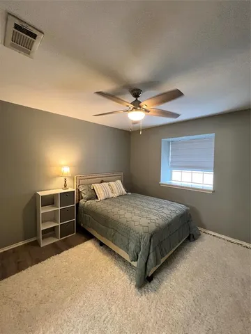 a spacious bedroom with a bed and a chandelier