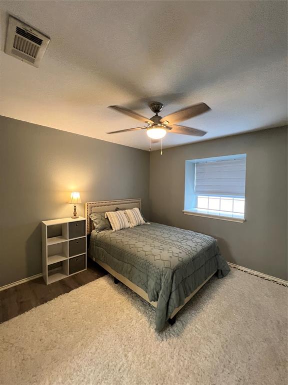 1337 South 11th Street Waco, TX 76706 - Photo 8 of 12 a spacious bedroom with a bed and a chandelier