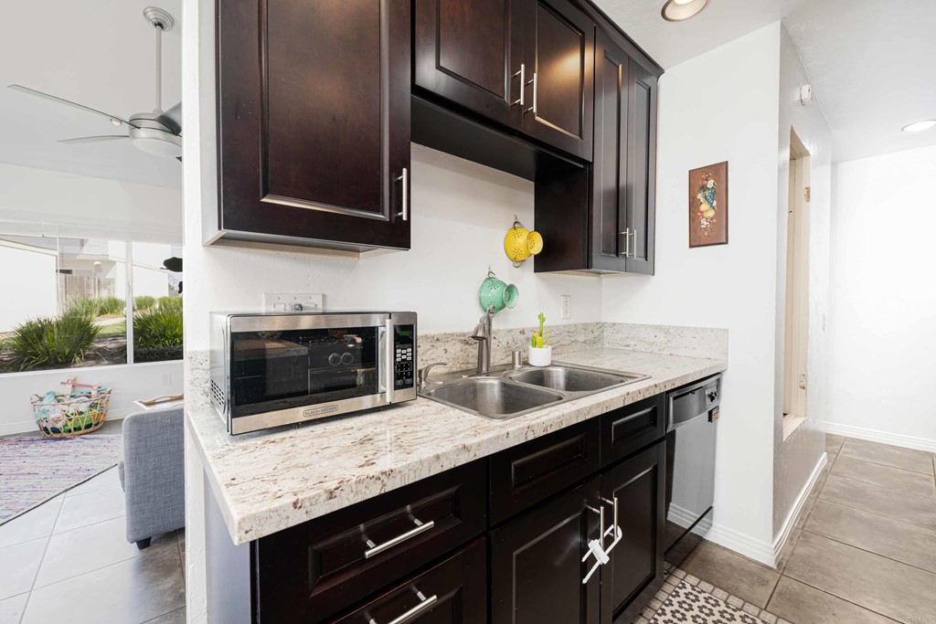 4159 Baycliff Way Oceanside, CA 92056 - Photo 12 of 23 a kitchen with granite countertop stainless steel appliances a sink stove and microwave