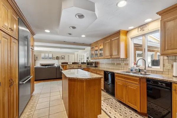 a kitchen with stainless steel appliances granite countertop a sink counter space cabinets and a large window