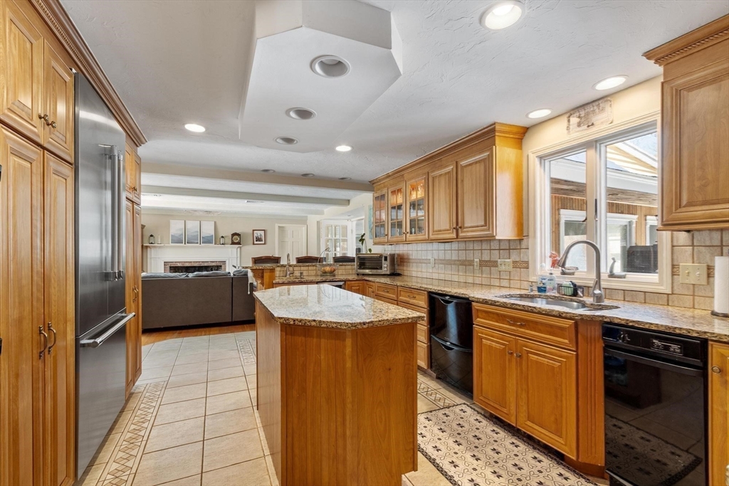 92 Prospect Street Lunenburg, MA 01462 - Photo 12 of 42 a kitchen with stainless steel appliances granite countertop a sink counter space cabinets and a large window