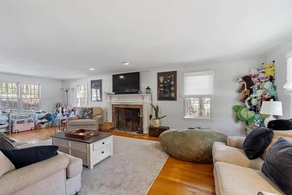 a living room with furniture fireplace and a window