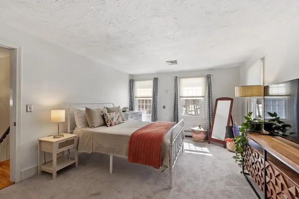 a bedroom with bed a lamp and window