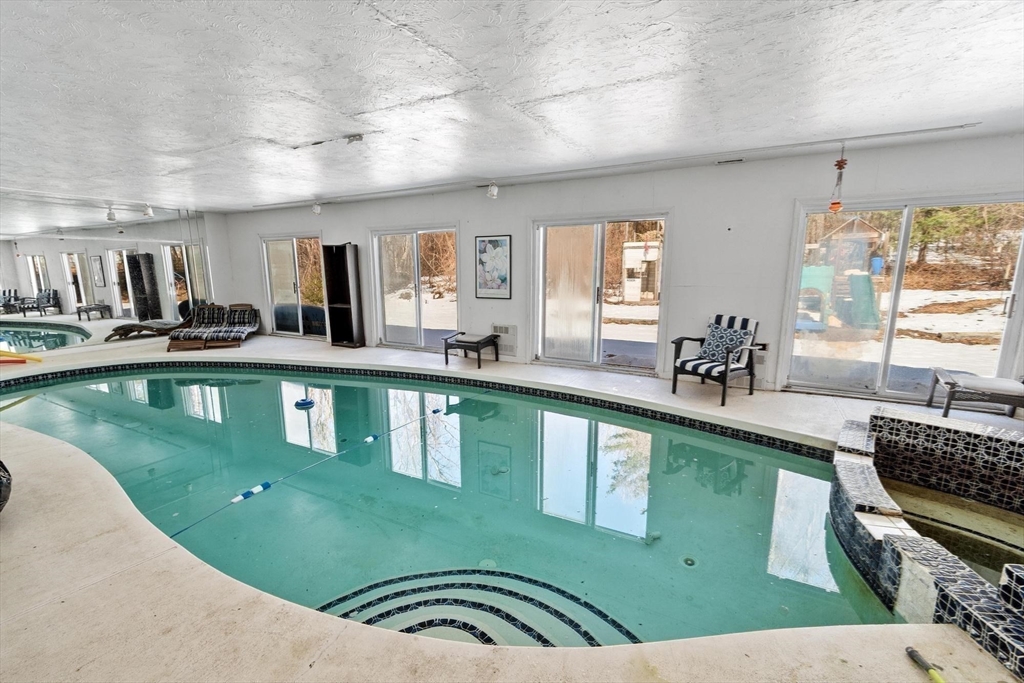 92 Prospect Street Lunenburg, MA 01462 - Photo 37 of 42 a kitchen with kitchen island granite countertop a sink a counter top space and living room view