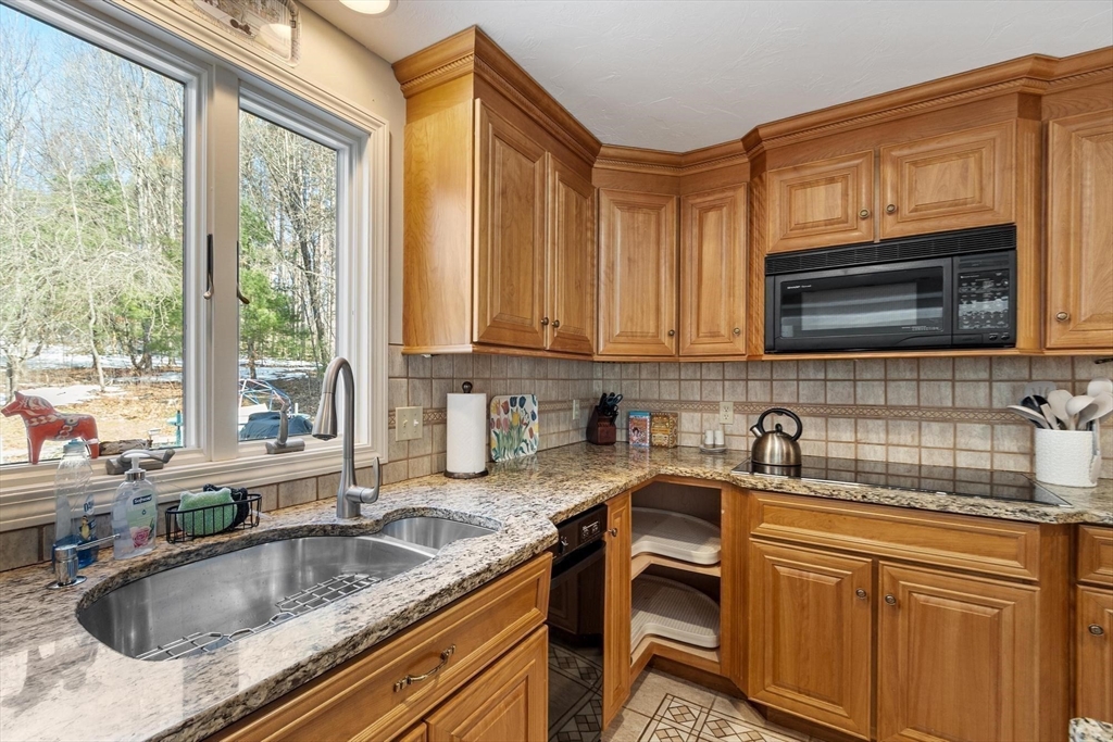 92 Prospect Street Lunenburg, MA 01462 - Photo 9 of 42 a kitchen with granite countertop a sink a counter space cabinets and stainless steel appliances