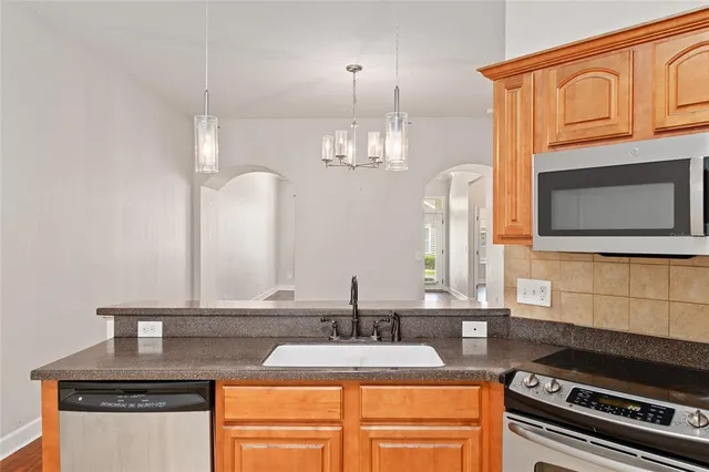 a kitchen with stainless steel appliances granite countertop a sink stove and microwave
