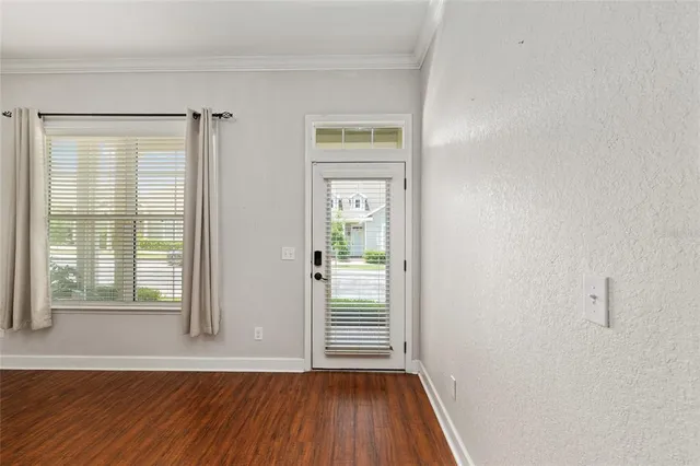 a view of a room with wooden floor and windows